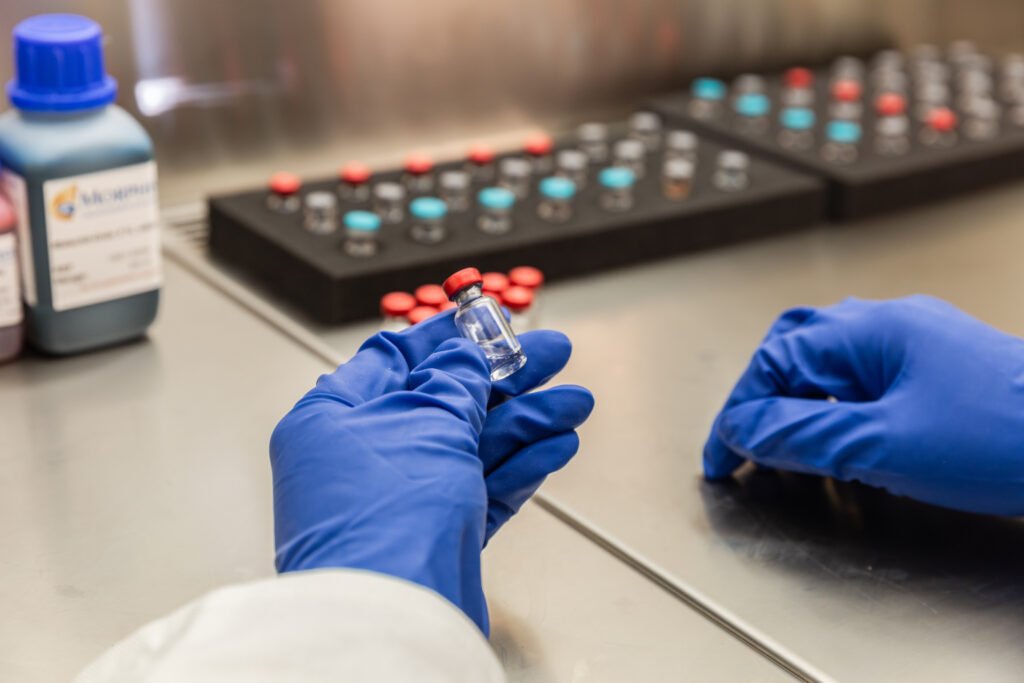 Vial being handled under a laminar flow bench at QPS
